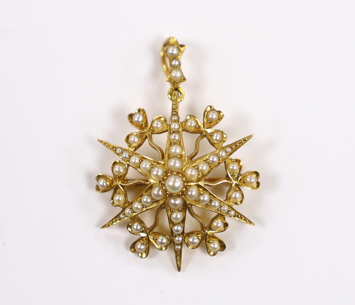 An Edwardian yellow metal and split pearl cluster set starburst pendant brooch, overall 38mm